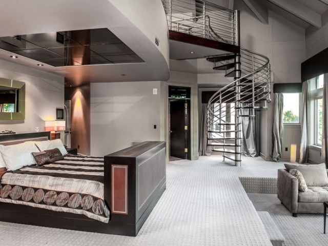 A steel staircase in the master bedroom leads to another floor