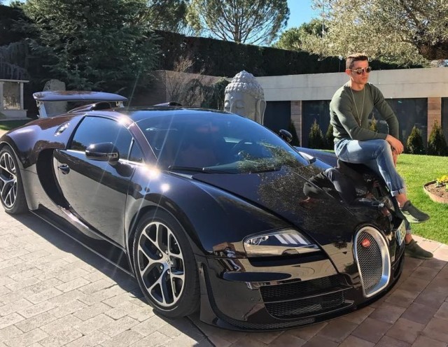 Cristiano Ronaldo poses outside his former Madrid home on his £1.7m Bugatti Veyron