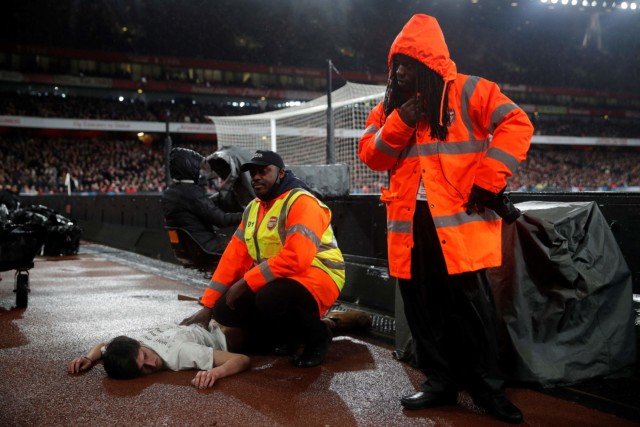 , Arsenal’s clash against Liverpool stopped after pitch invader HANDCUFFS himself to goal post
