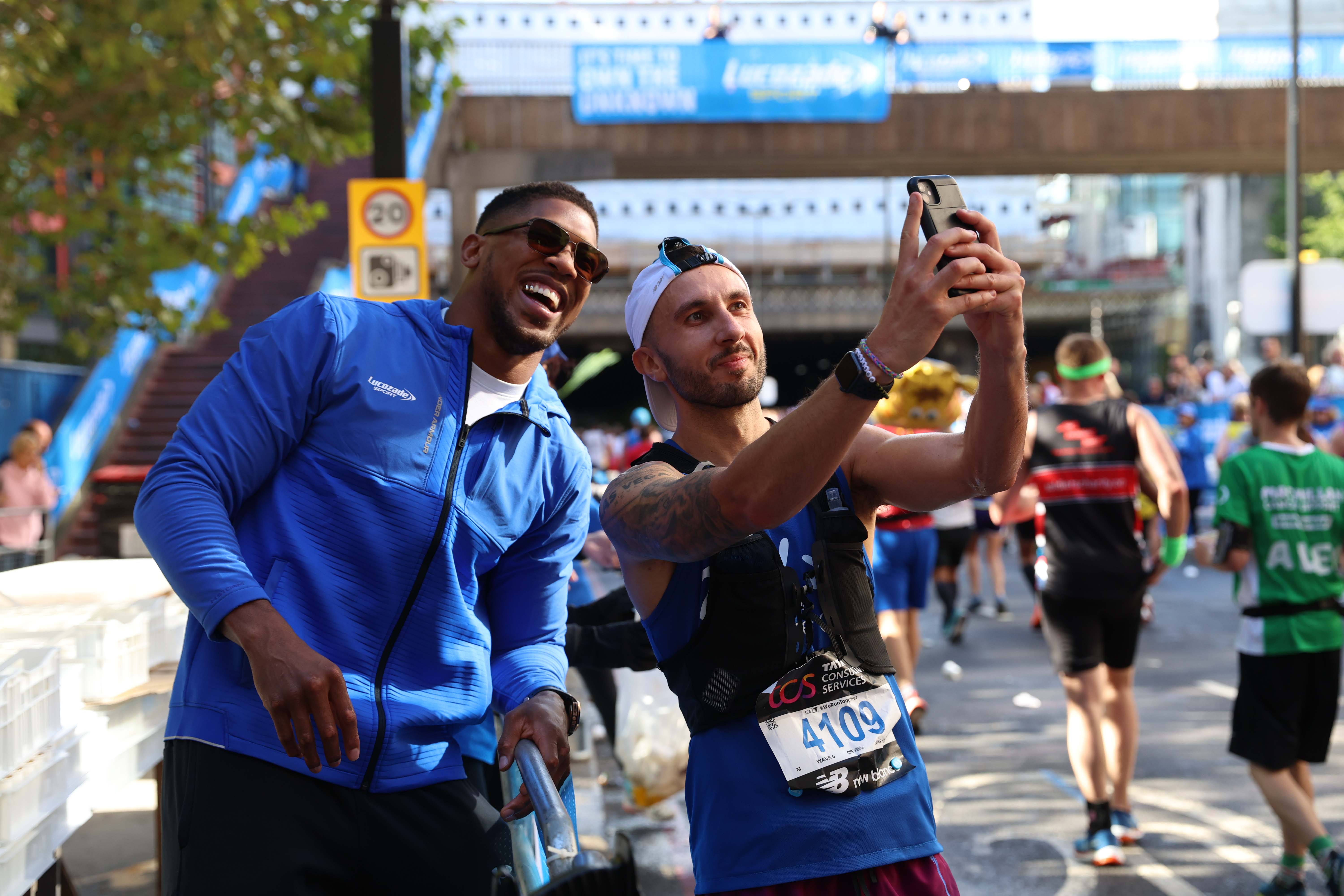 , Anthony Joshua hands out drinks to stunned London Marathon runners who stop for selfies as Tyson Fury talks rumble on